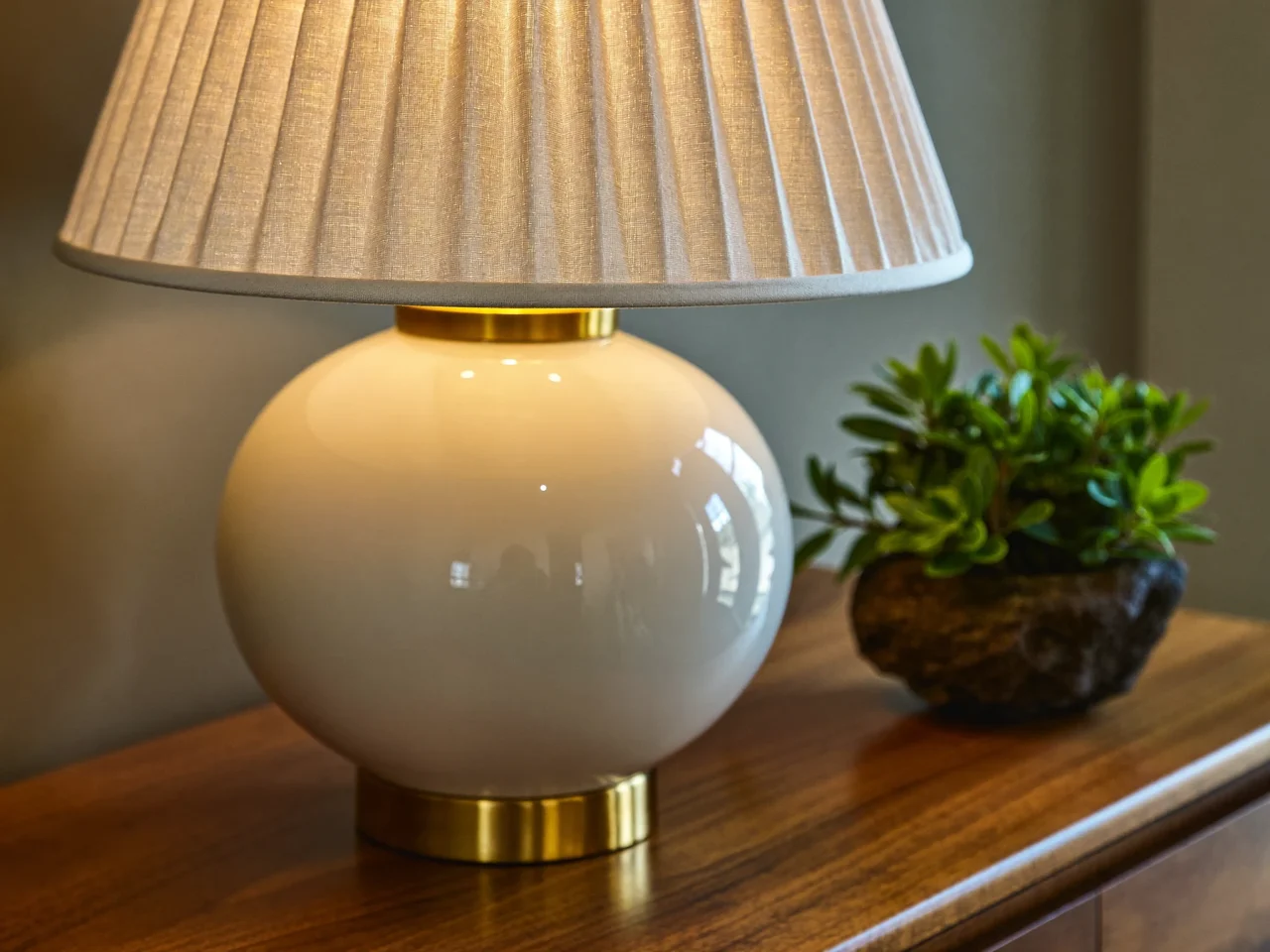 Lampe à poser à abat-jour en lin plissé sur un buffet en noyer